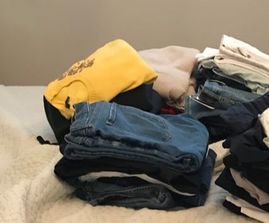 Pile of sweaters and jeans to organize