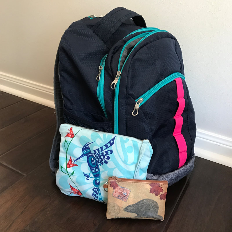 Navy backpack with a pink stripe.  Two small pencil bags visible.