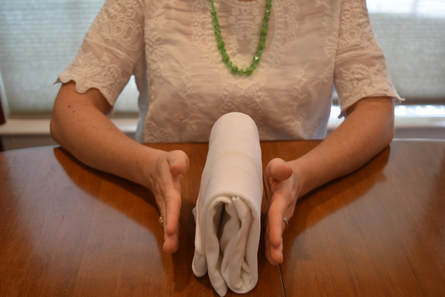 Laura Sinclair professional home organizer of Flourish Organizing showcasing a white shirt folded using the KonMari Method
