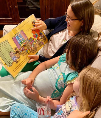 Picture of Laura Sinclair reading to two children from the Kiki and Jax picture book by Marie Kondo.  Kids are in pajamas and curled up on the couch.